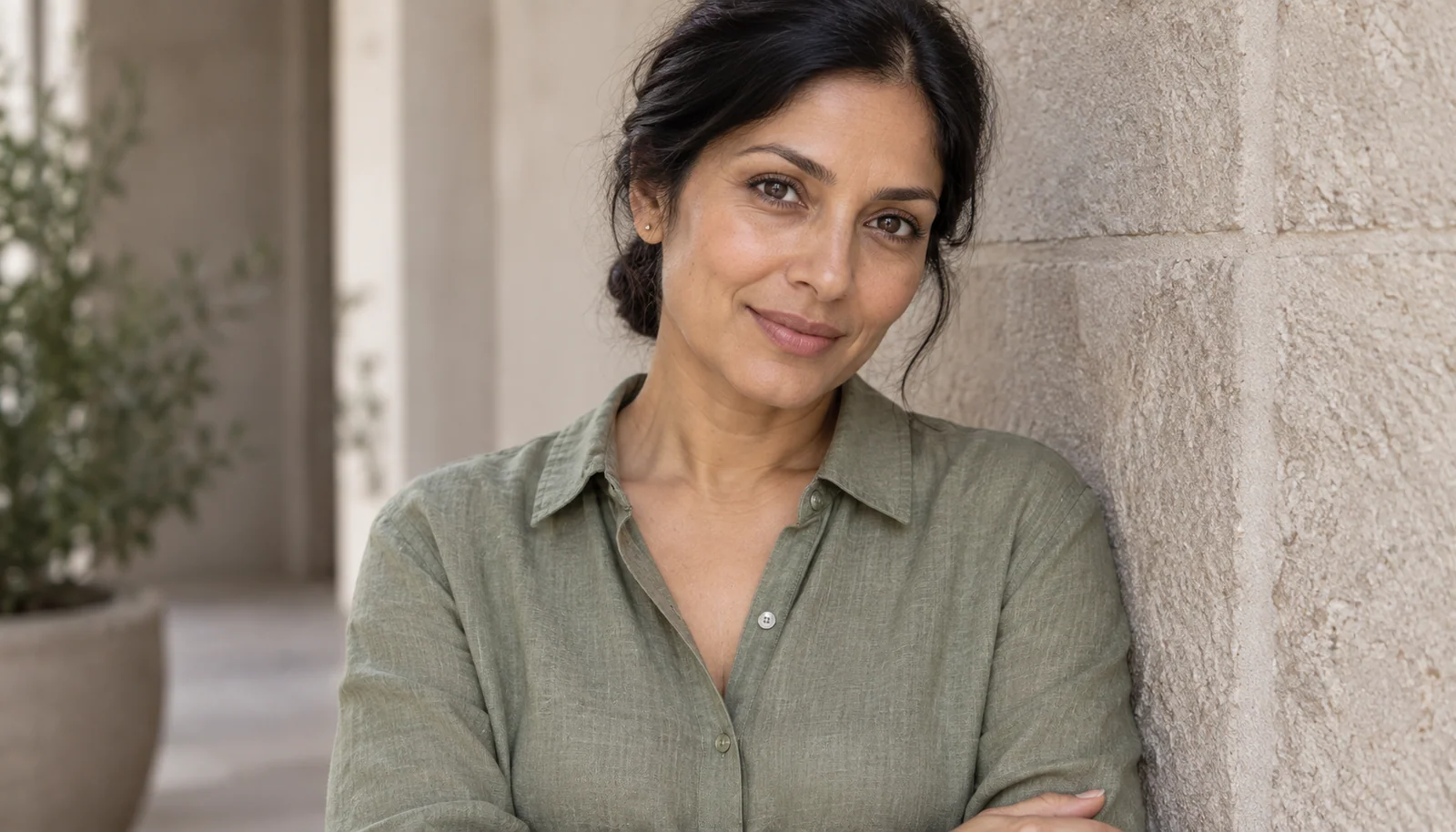 Woman with understated lip colour in a shaded courtyard