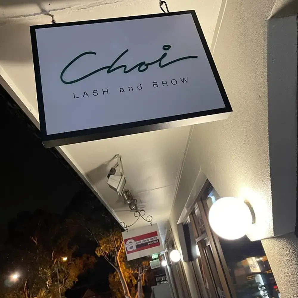 The Choi Lash and Brow sign lit at night on Burns Bay Road